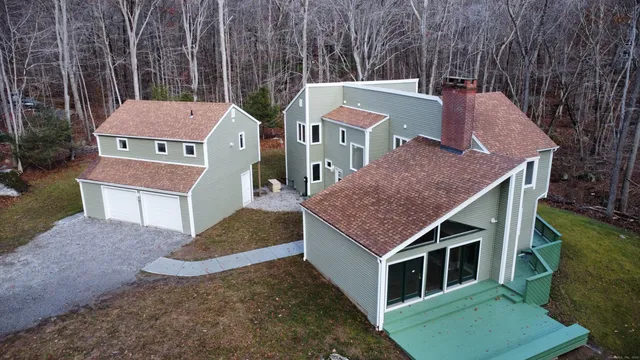 a aerial view of a house with a yard and large trees