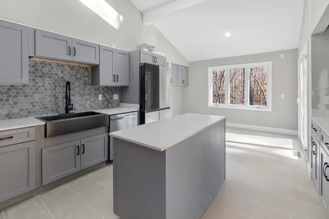 a kitchen with white cabinets and a refrigerator