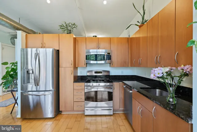 a kitchen with stainless steel appliances a stove a refrigerator and a sink