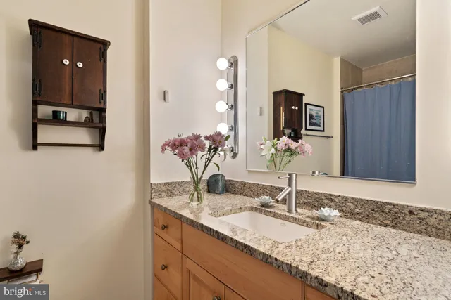 a bathroom with a granite countertop sink and a mirror