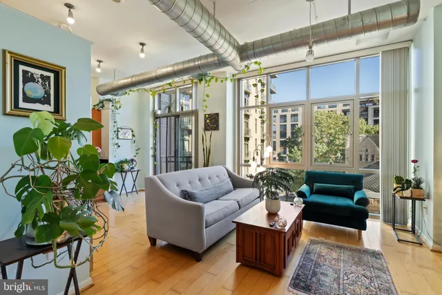 a living room with furniture and a large window with wooden floor