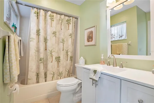 a bathroom with a sink a toilet a mirror a vanity and shower