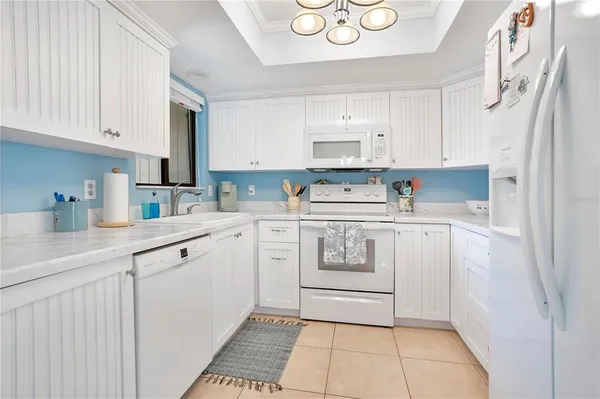 a kitchen with white cabinets and white appliances