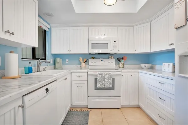 a kitchen with cabinets appliances a sink and a counter top space