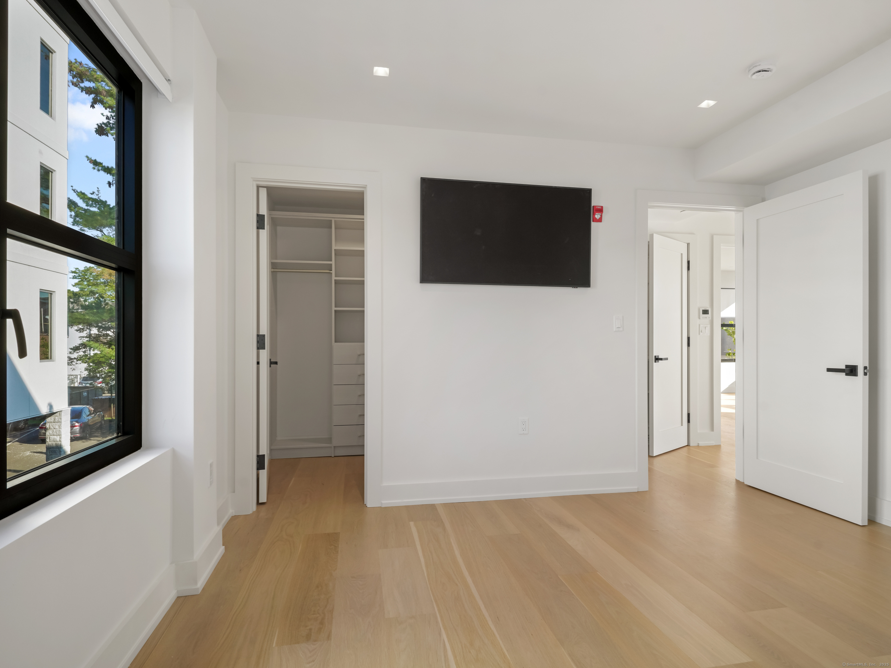 116 Sherman Street, Unit 1 Fairfield, CT 06824 - Photo 12 of 32 a view of hallway with wooden floor and windows