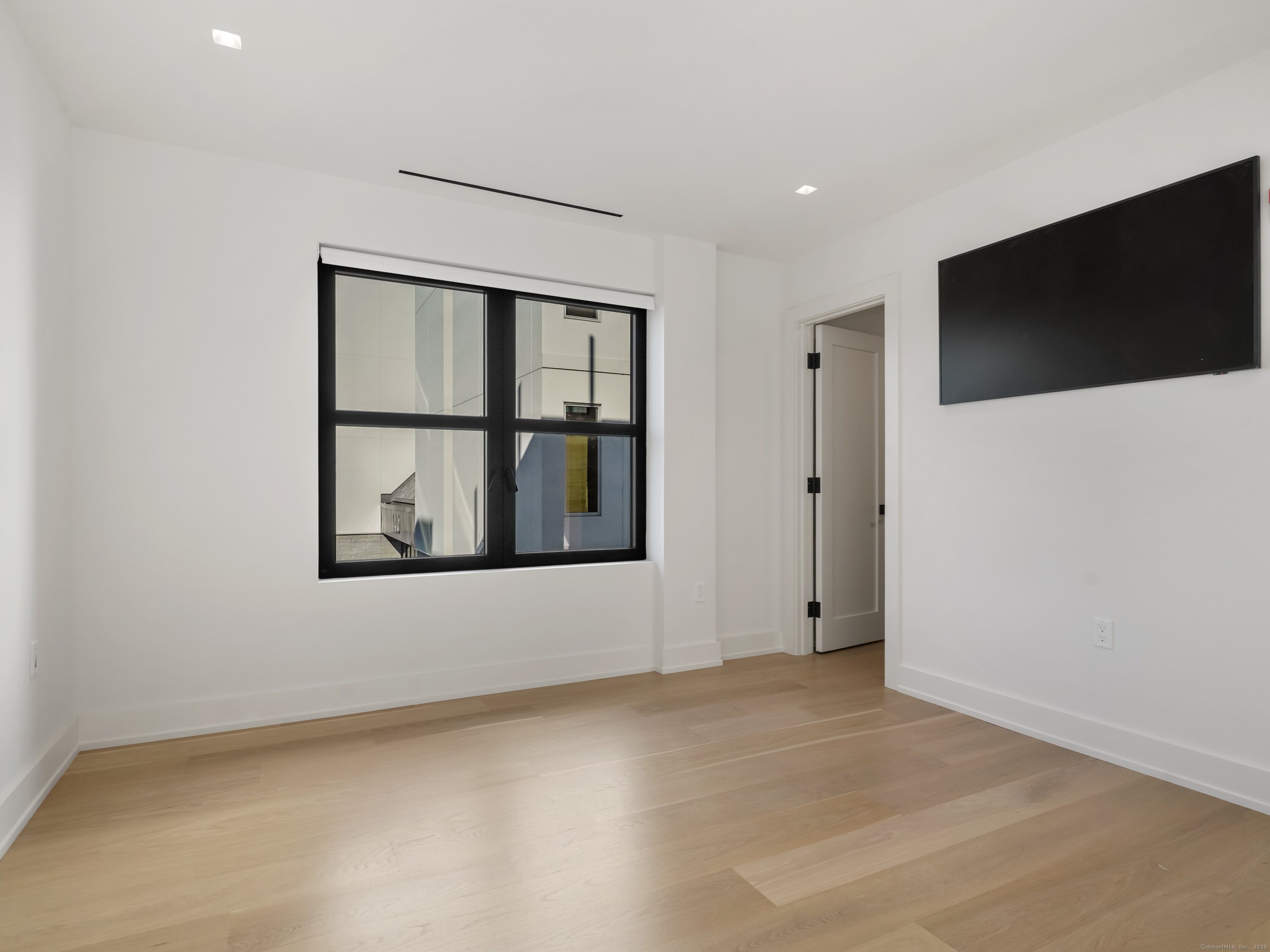 116 Sherman Street, Unit 1 Fairfield, CT 06824 - Photo 13 of 32 a view of an empty room with a flat screen tv