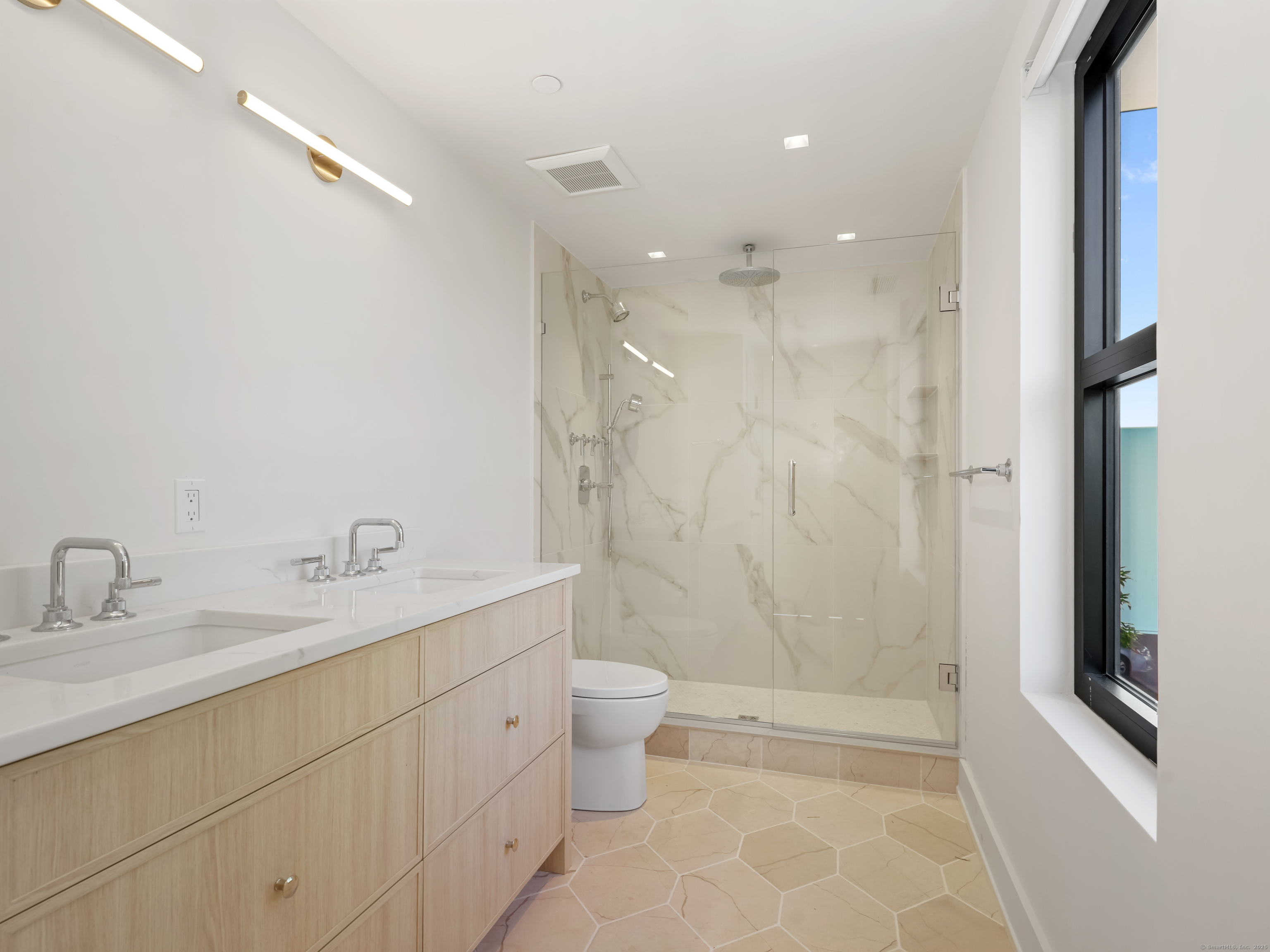 116 Sherman Street, Unit 1 Fairfield, CT 06824 - Photo 24 of 32 a bathroom with a double vanity sink toilet and shower