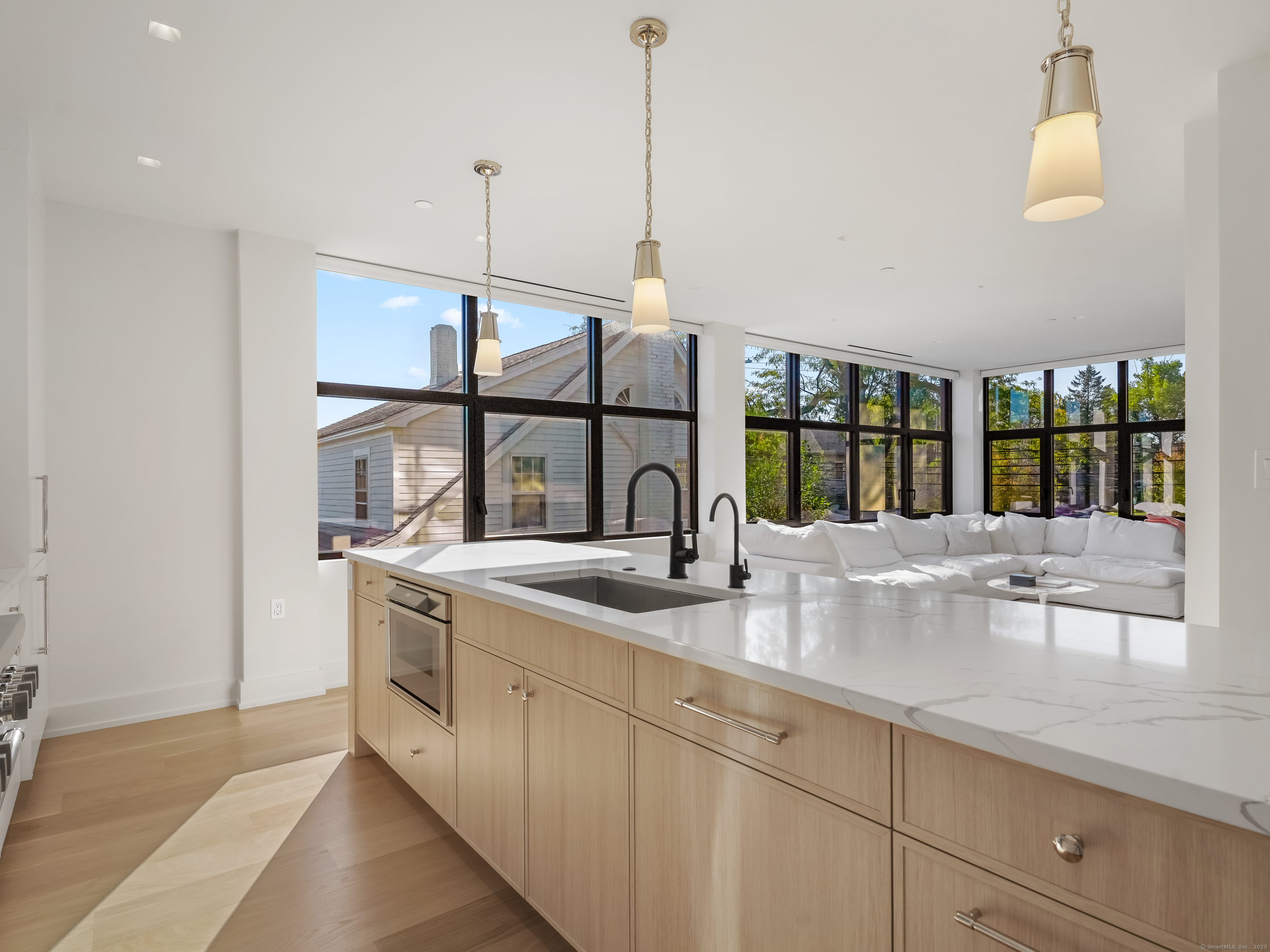 116 Sherman Street, Unit 1 Fairfield, CT 06824 - Photo 6 of 32 a kitchen with kitchen island a sink a stove and a window with wooden floor