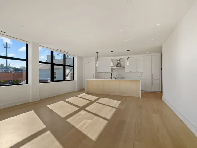 a living room with stainless steel appliances furniture and next to a window