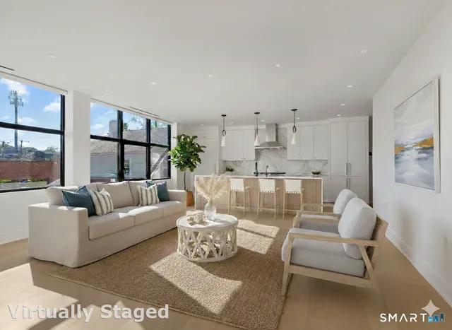 a kitchen with stainless steel appliances granite countertop a stove a sink and a refrigerator with white cabinets