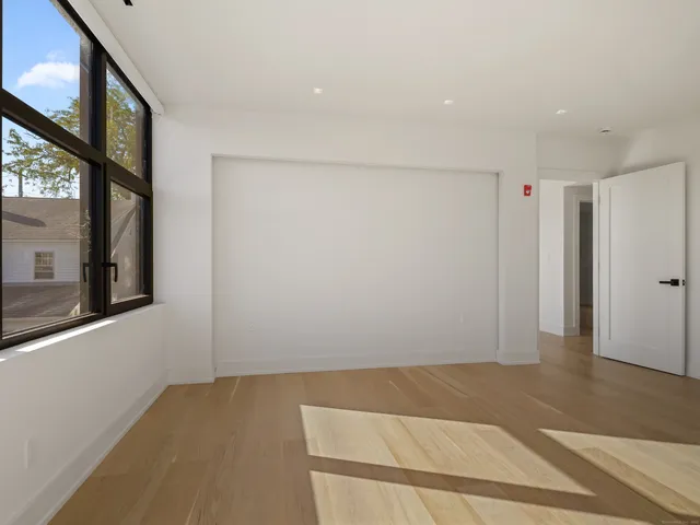 a view of hallway with wooden floor and windows