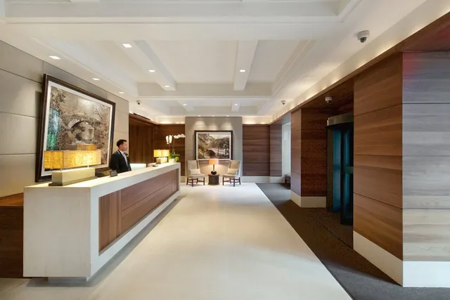 a large living room with stainless steel appliances kitchen island granite countertop a large window and a couch