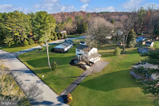 an aerial view of a house with a yard and trees