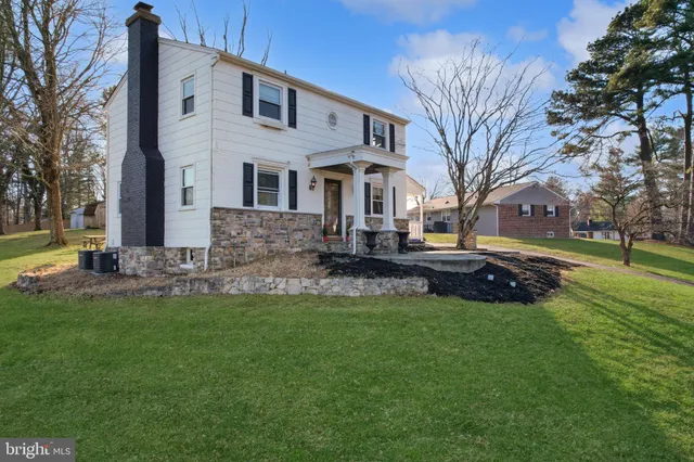 a front view of a house with a yard table and trees