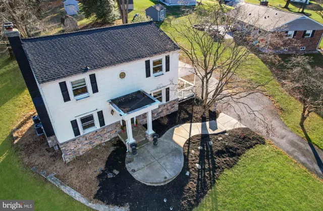 an aerial view of a house with a yard basket ball court and outdoor seating