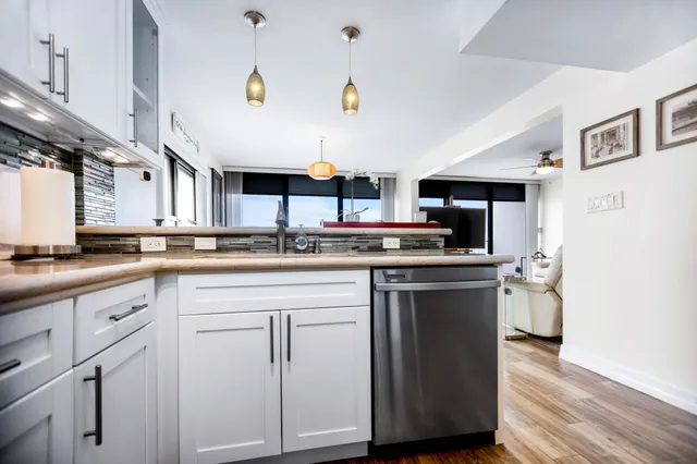 a living room with furniture kitchen view and a wooden floor