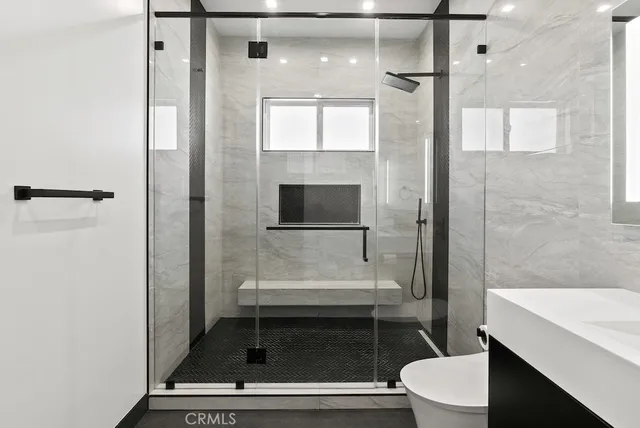 a bedroom with a bed and a flat tv screen on a dresser