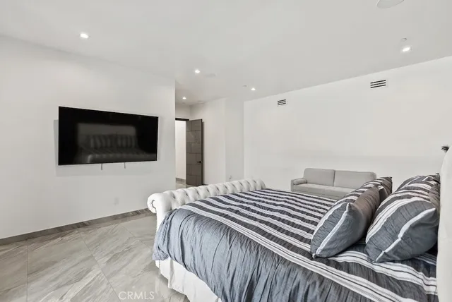 a bedroom with a bed and a flat screen tv