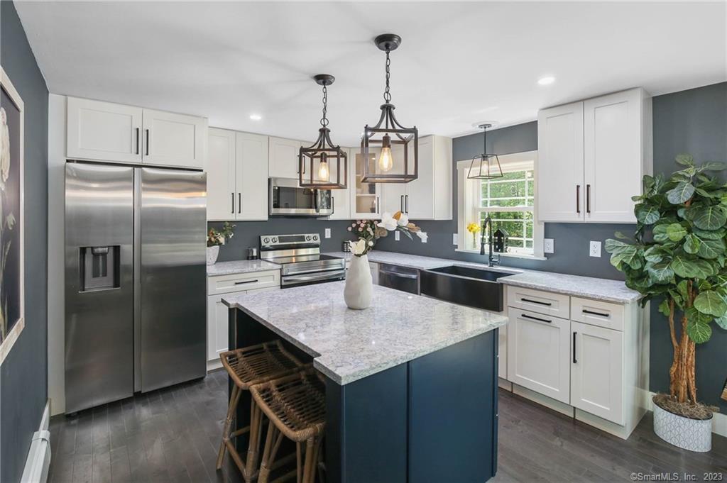 a kitchen with stainless steel appliances a center island cabinets and a refrigerator