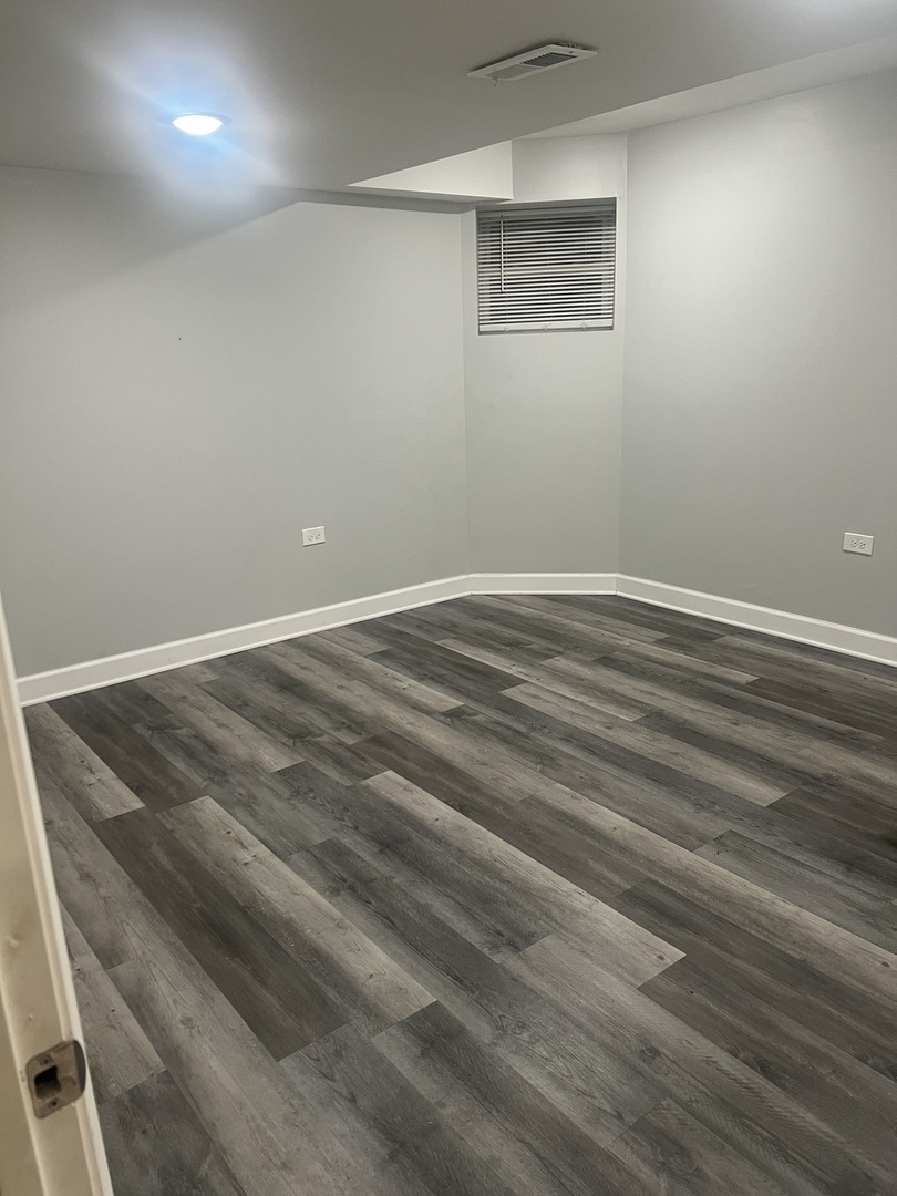 4740 South Prairie Avenue, Unit G Chicago, IL 60615 - Photo 7 of 9 a view of a room with wooden floor and windows