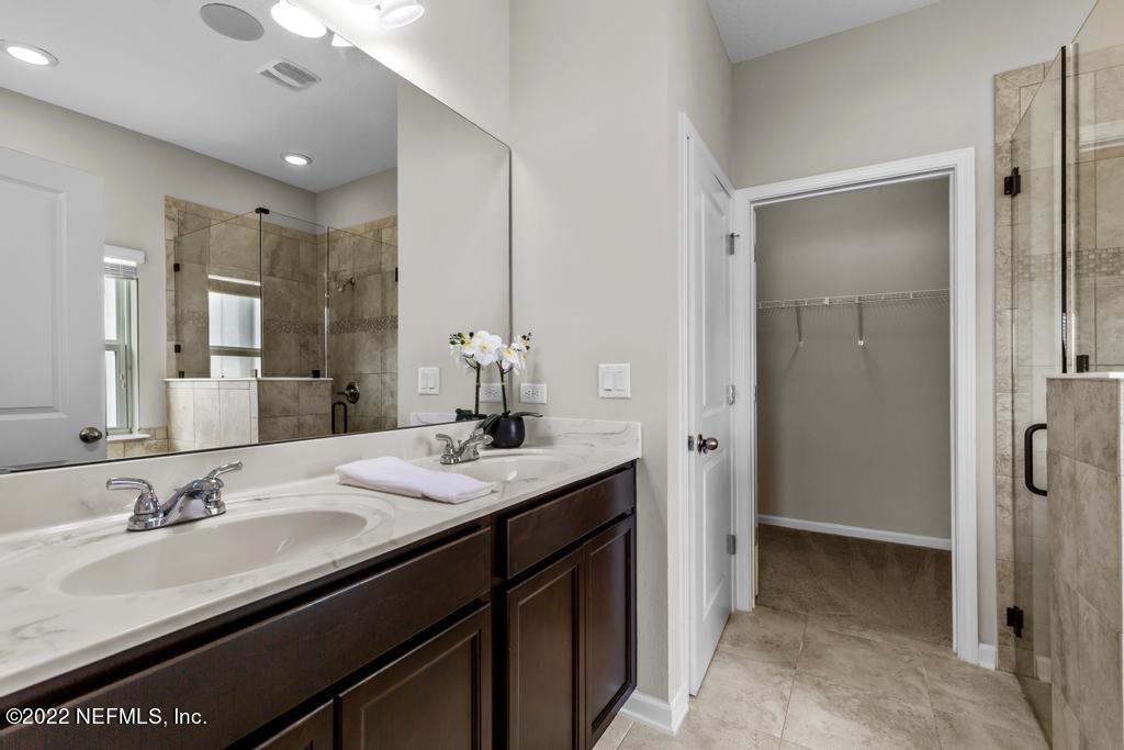 9802 Kevin Road Jacksonville, FL 32257 - Photo 11 of 22 a bathroom with a sink double vanity granite tub shower and a mirror