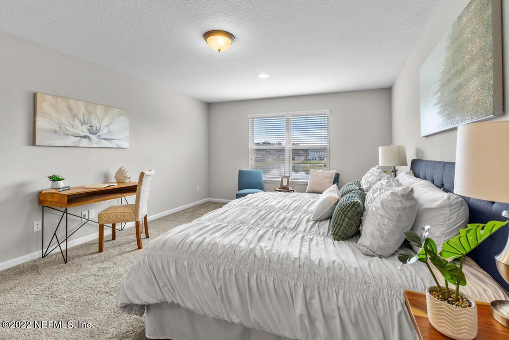 9802 Kevin Road Jacksonville, FL 32257 - Photo 14 of 22 a bedroom with a bed and a chandelier