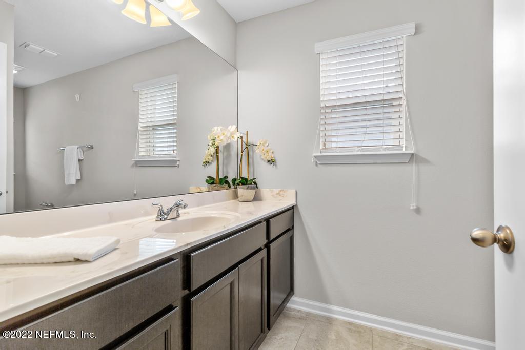 9802 Kevin Road Jacksonville, FL 32257 - Photo 16 of 22 a bathroom with a granite countertop sink and a window
