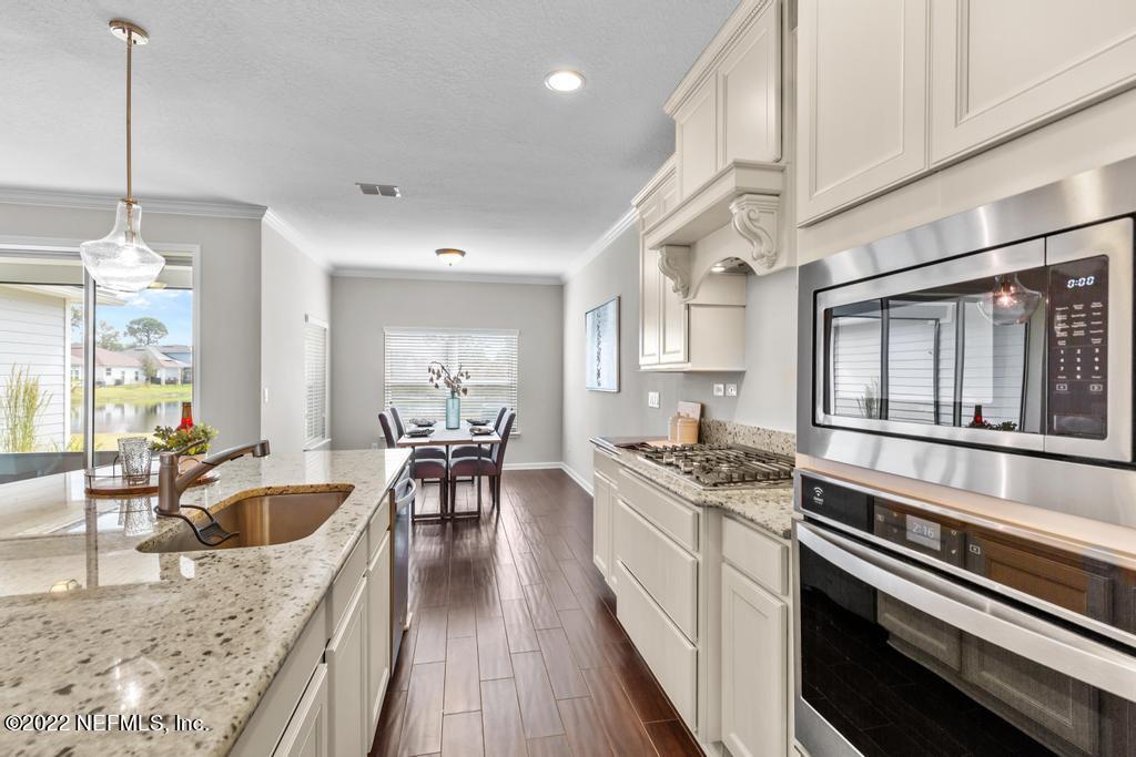 9802 Kevin Road Jacksonville, FL 32257 - Photo 6 of 22 a kitchen with stainless steel appliances granite countertop a sink stove and wooden floor