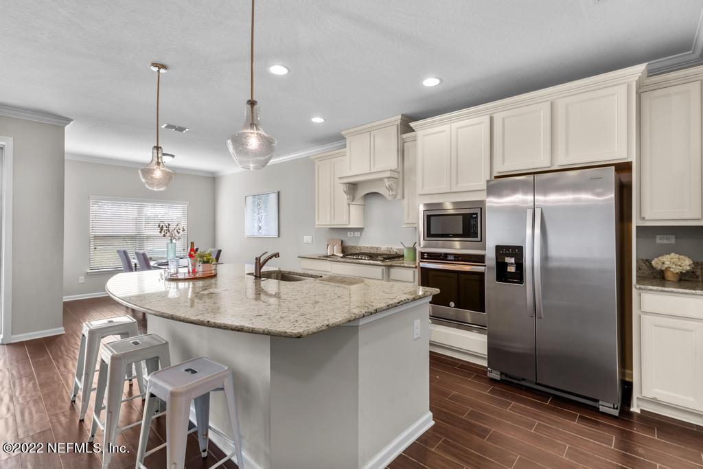 9802 Kevin Road Jacksonville, FL 32257 - Photo 8 of 22 a kitchen with stainless steel appliances granite countertop a sink a stove a refrigerator cabinets and a dining table