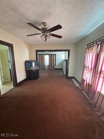 870 Helmsdale Road Cleveland Heights, OH 44112 - Photo 4 of 20 Unfurnished living room featuring a textured ceiling, dark carpet, and ceiling fan