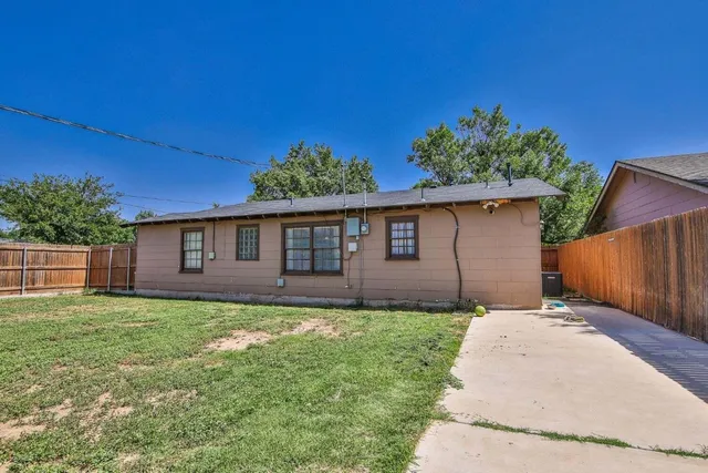 a backyard of a house with table and chairs