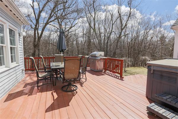 131 Harvard Road Bolton, MA 01740 - Photo 30 of 30 a view of a roof deck with table and chairs couches and a barbeque with wooden floor and fence