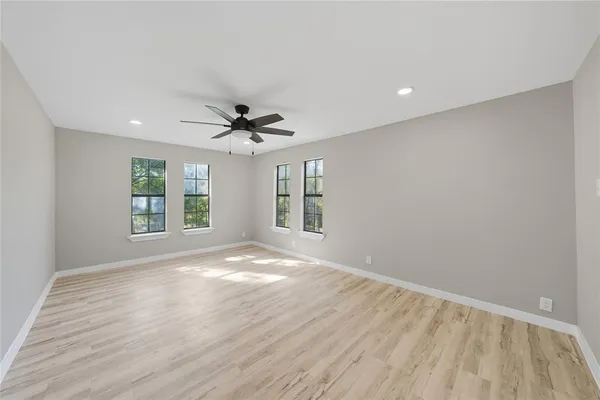 a view of an empty room with a window and wooden floor