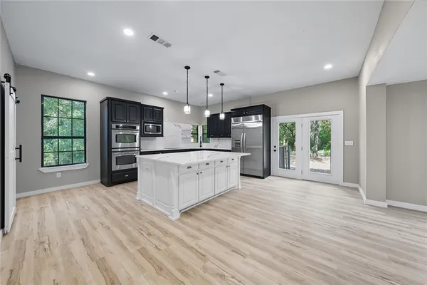 a large kitchen with a wooden floor and a large window
