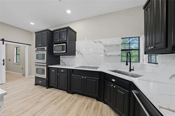 a kitchen with stainless steel appliances granite countertop wooden cabinets a sink and dishwasher