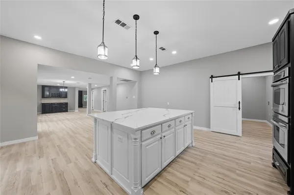 a kitchen with a stove a refrigerator a center island with wooden floor