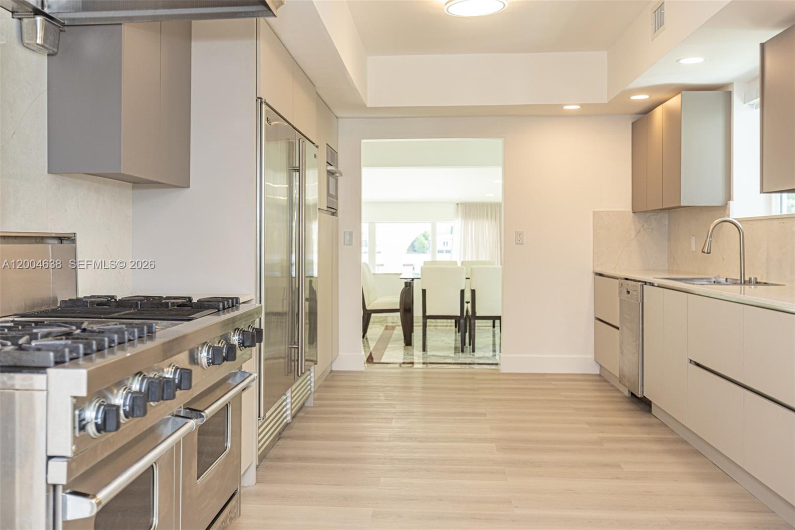 1690 Daytonia Road Miami Beach, FL 33141 - Photo 74 of 88 a kitchen with stainless steel appliances granite countertop a stove and a refrigerator