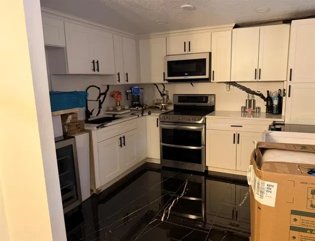 a kitchen with a sink stove and microwave