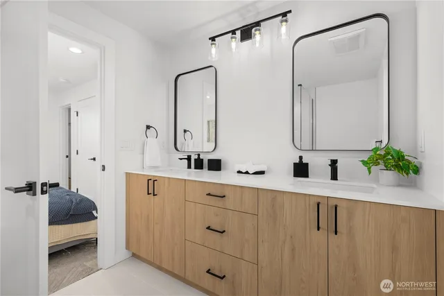 a en suite bathroom with a sink a shower and a mirror