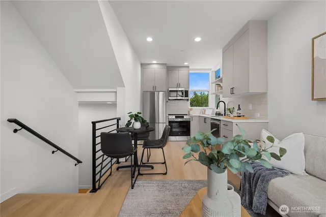 a living room with furniture kitchen and a potted plant