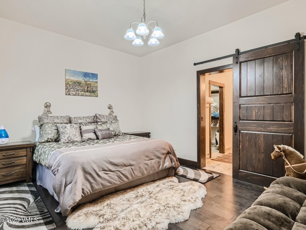 67 Robins Egg Eagle, CO 81631 - Photo 29 of 38 a bedroom with a bed and a chandelier