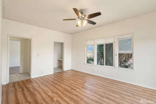 a view of a livingroom with wooden floor and a ceiling fan