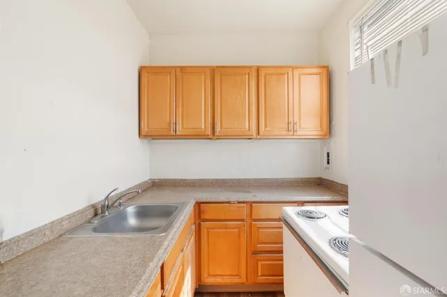 a kitchen with a sink cabinets and a window