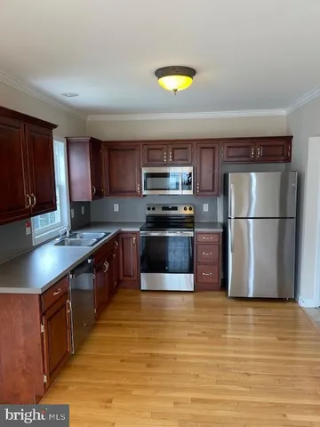 a kitchen with stainless steel appliances granite countertop a refrigerator a stove a sink dishwasher and a microwave