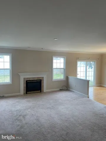 an empty room with a fireplace and windows
