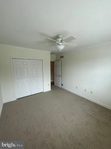 a view of an empty room with a ceiling fan