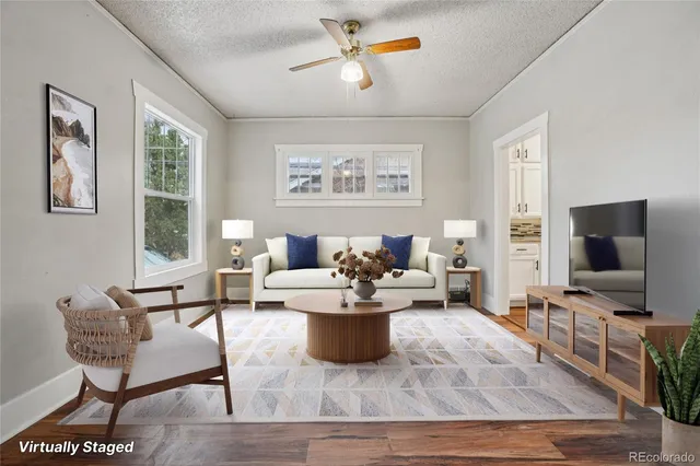 a living room with furniture a flat screen tv and a window