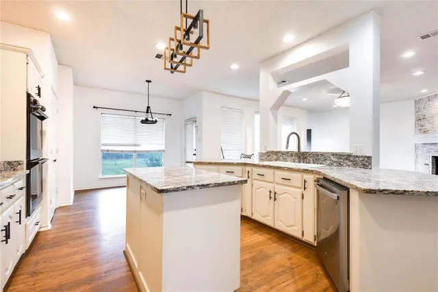 a kitchen with granite countertop kitchen island and stainless steel appliances
