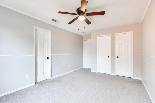 a view of an empty room with a ceiling fan