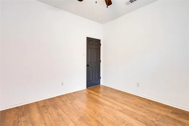 an empty room with a window and ceiling fan